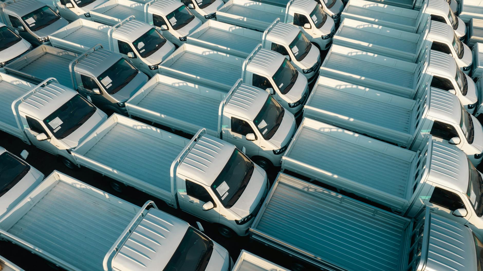 Białe pickupy flotowe widziane z lotu ptaka na parkingu