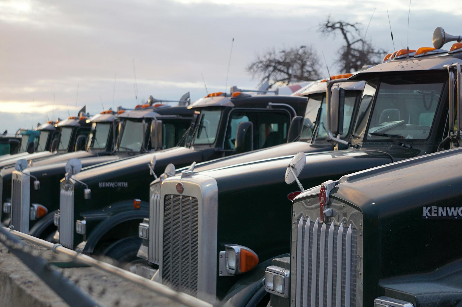 Rząd klasycznych ciężarówek Kenworth na parkingu transportu ciężkiego