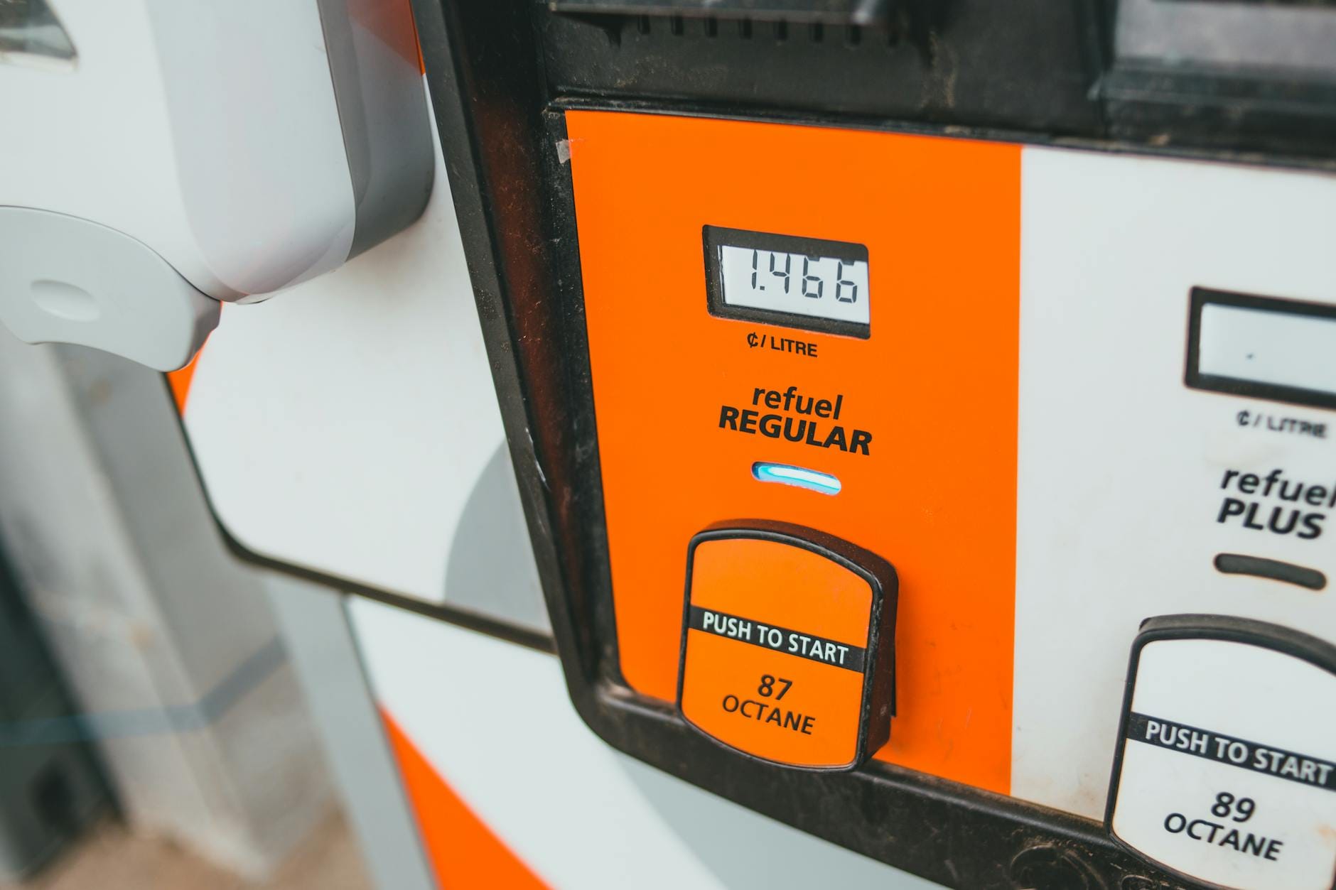 Zbliżenie na dystrybutor paliwa z wyświetloną ceną i oznaczeniem 87