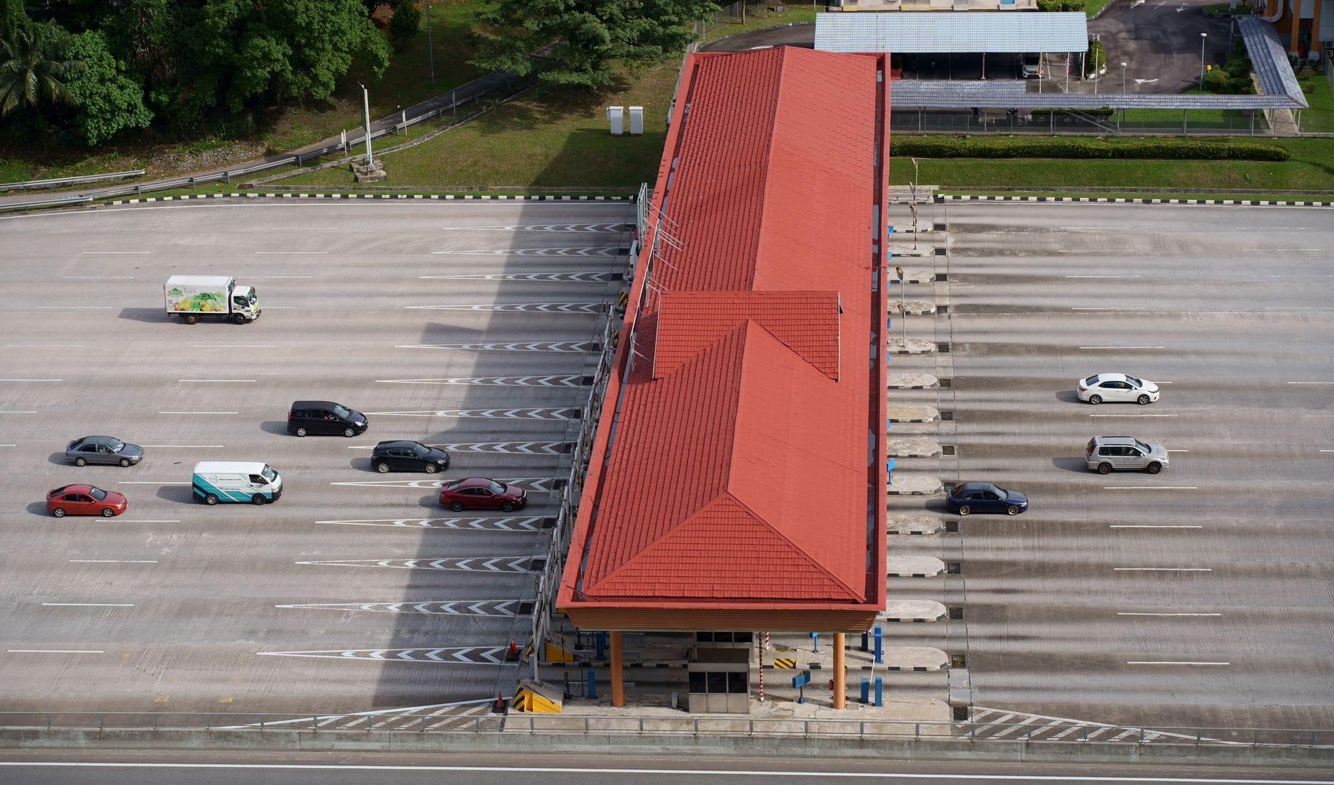 Jak czytać i optymalizować faktury za opłaty drogowe, e-TOLL i myto w Europie Lotniczy widok na plac poboru opłat z ciężarówkami i autami na autostradzie