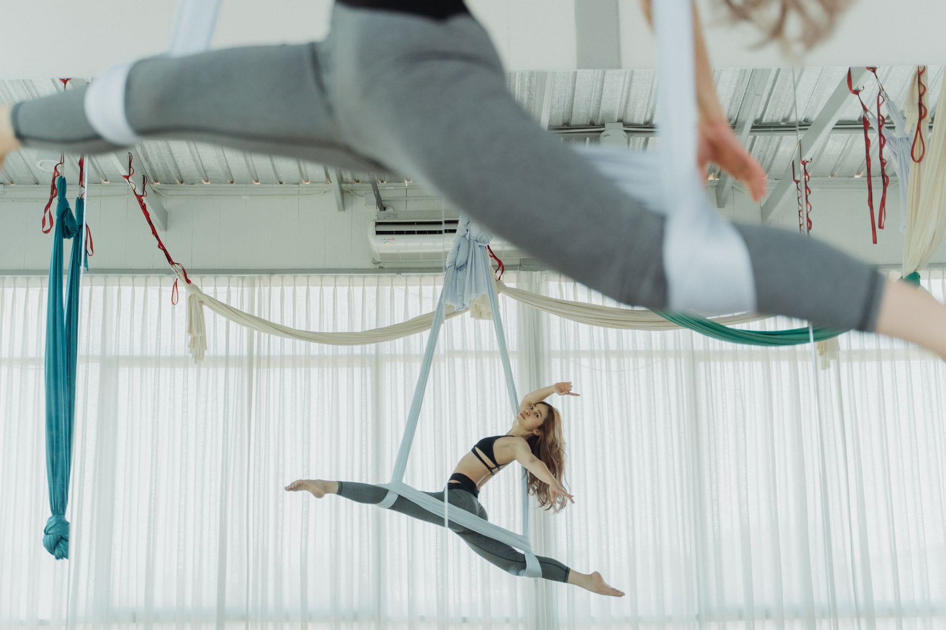 Młoda kobieta ćwiczy figury aerial hoop w jasnym studiu