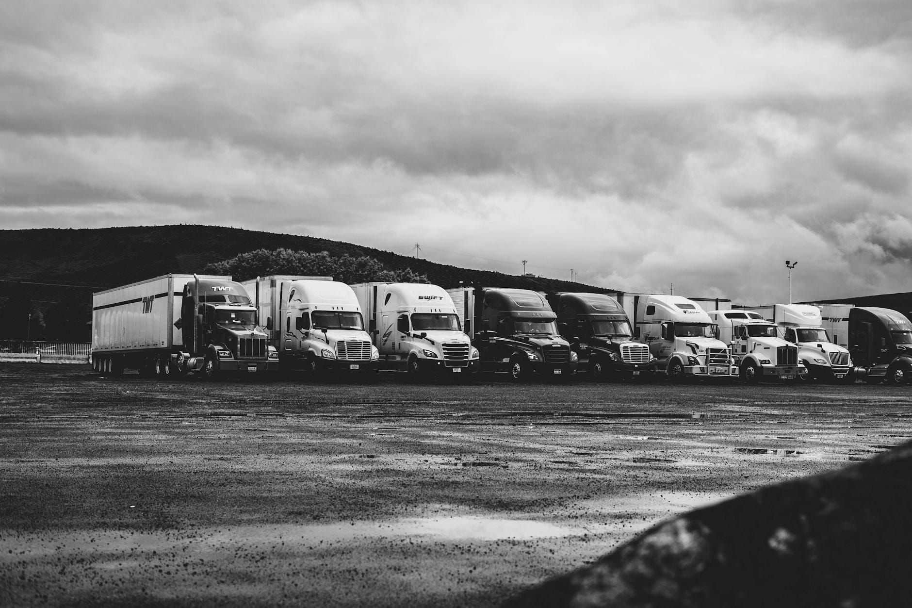 Zaparkowane ciężarówki na mokrym parkingu w deszczowy dzień